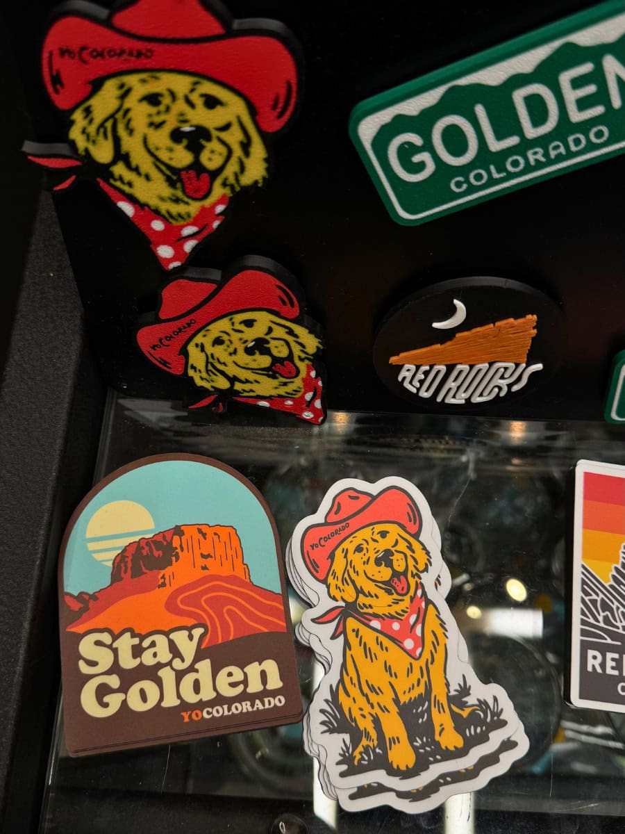 Goldens in Golden stickers and magnets arranged together on a flat surface.
