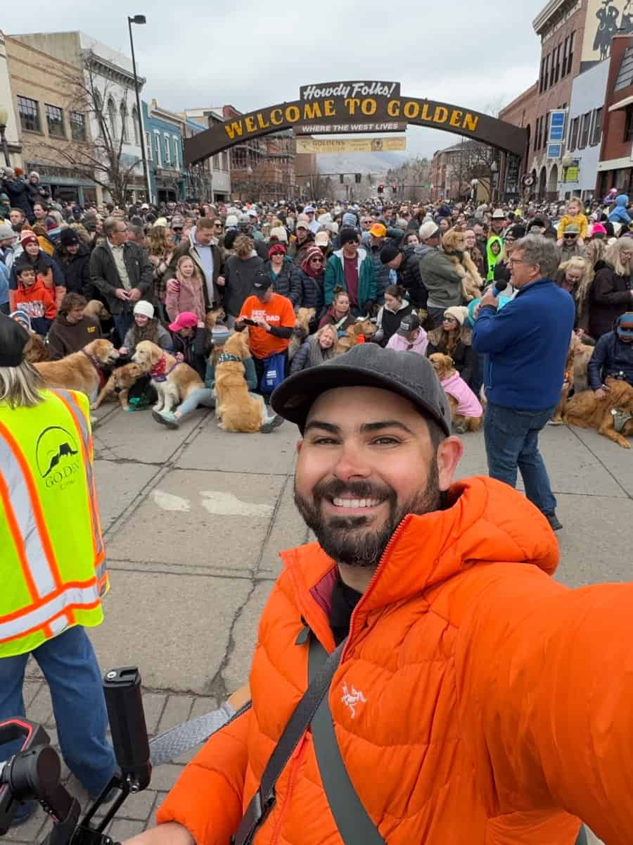 Person taking a selfie in front of the Welcome to Golden sign moments before the group photo at the Goldens in Golden 2025 event.