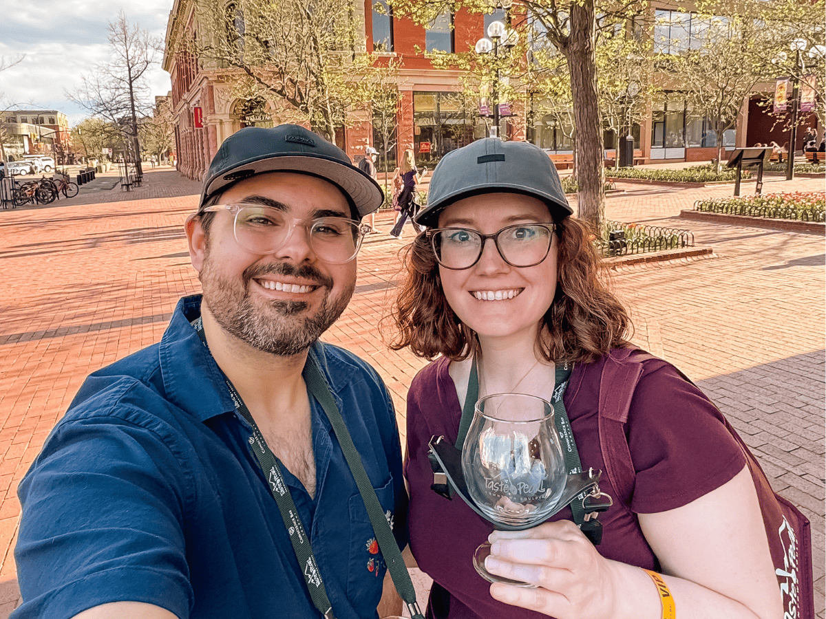 Happy couple exploring Pearl Street in Boulder, Colorado, enjoying local food and vibrant city atmos.
