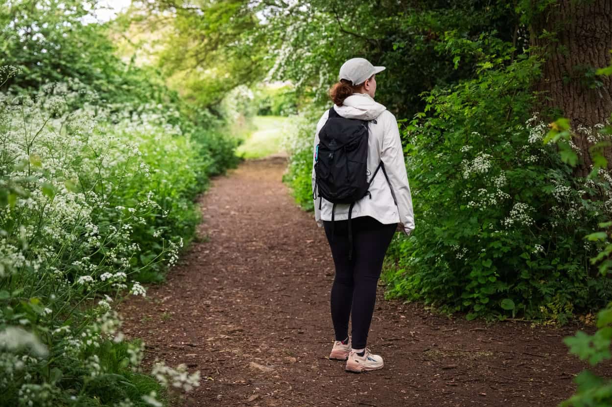 Katie wearing a 20-liter Gregory daypack while walking in the English countryside. Macs Adventure Review.