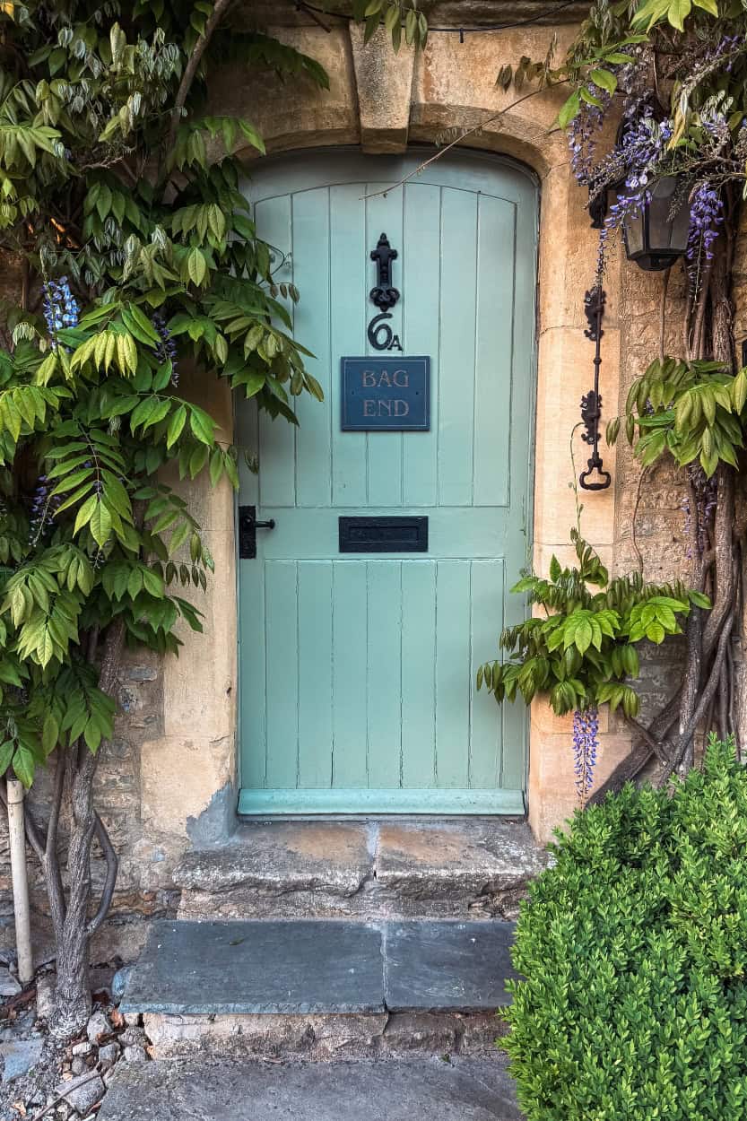 Teal door of Bag End house with vines walking the Cotswolds near Moreton-in-Marsh