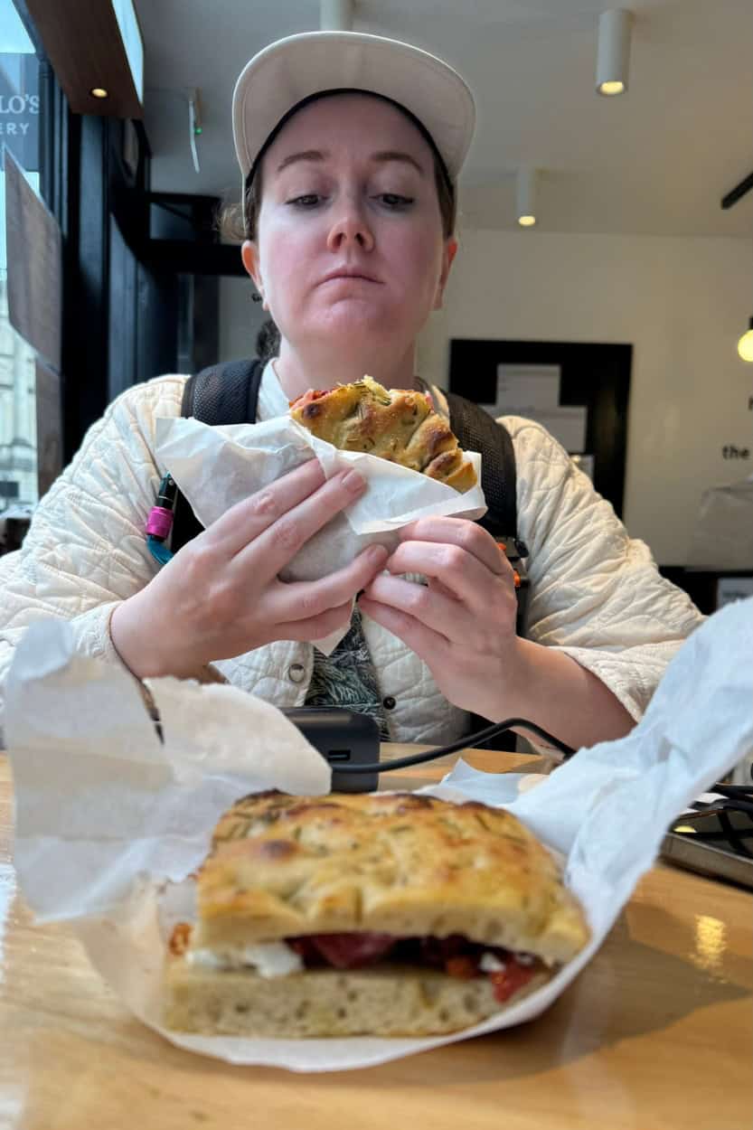 Katie sitting at Angelo's Bakery in Bath, England after finishing her sandwich