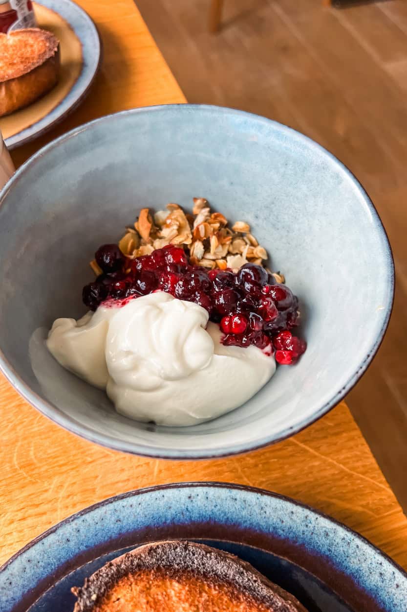 Bowl of yogurt over fresh granola topped with berry compote at Boskerris Hotel in St. Ives