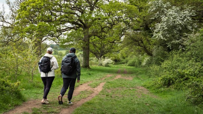 Couple walking the Cotswolds countryside trail England