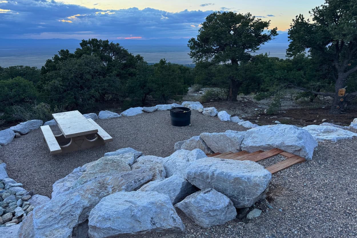 Campsite fire pit and picnic table at Zapata Falls Campground near Great Sand Dunes National Park