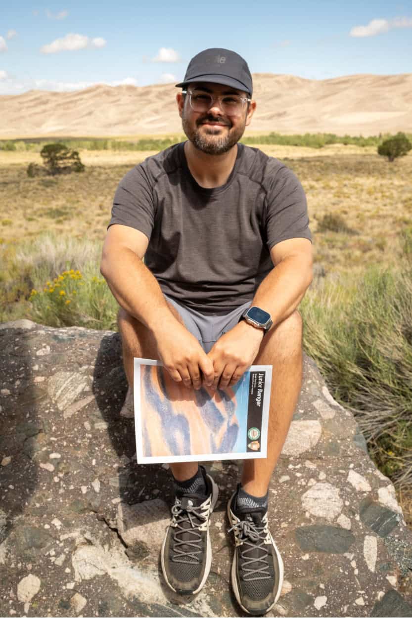 Man completing a Junior Ranger booklet at Great Sand Dunes National Park in Colorado