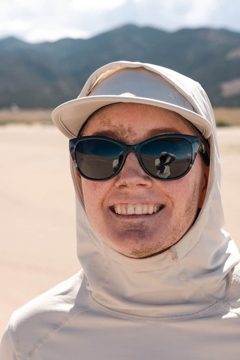 Woman with a face full of sand after a sandboarding fall at Great Sand Dunes National Park
