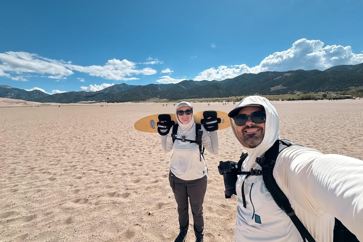 Couple carrying sand boards at Great Sand Dunes National Park in Colorado