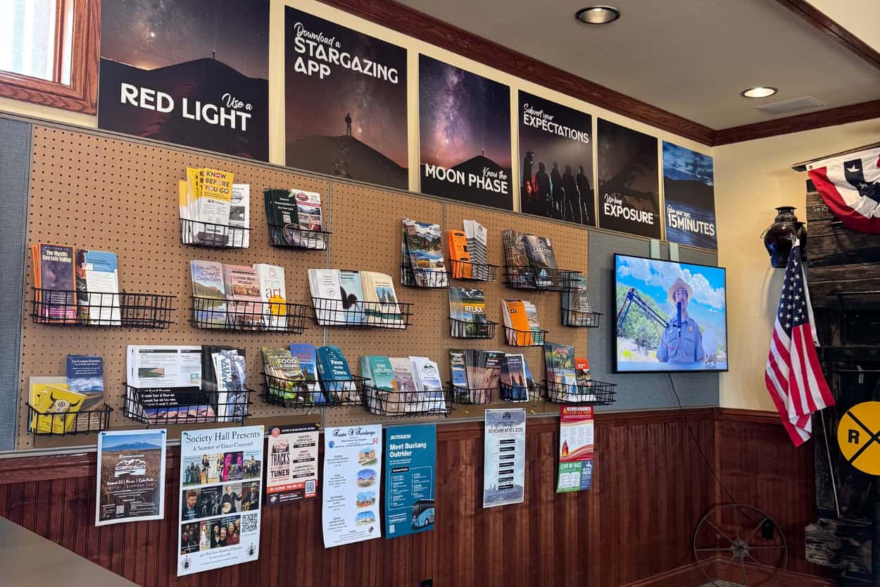 Wall of travel pamphlets inside the Alamosa Visitor Center in Colorado
